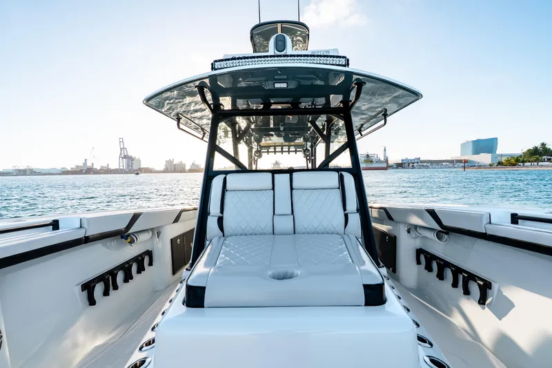 Slide: The Image of 2023 Yellowfin 42 Offshore boat interior with luxurious seating, docked in a scenic harbor. - 27