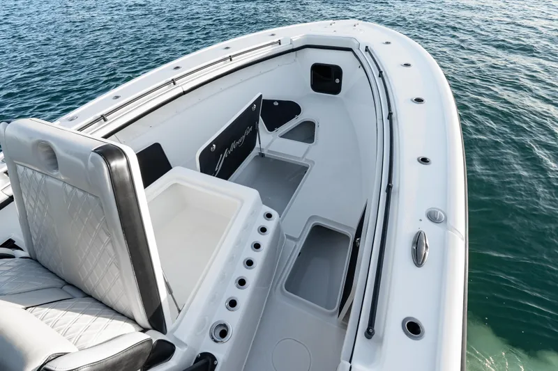 Slide: The Image of 2023 Yellowfin 42 Offshore boat interior with seating and storage, on calm water. - 36