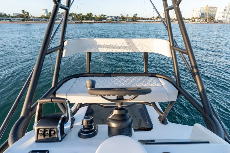 Slide: The Image of 2023 Yellowfin 42 Offshore boat helm with ocean view and coastal background. - 48