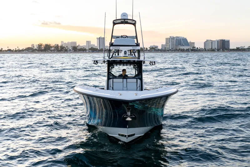 Slide: The Image of 2023 Yellowfin 42 Offshore boat on water with city skyline backdrop. - 8