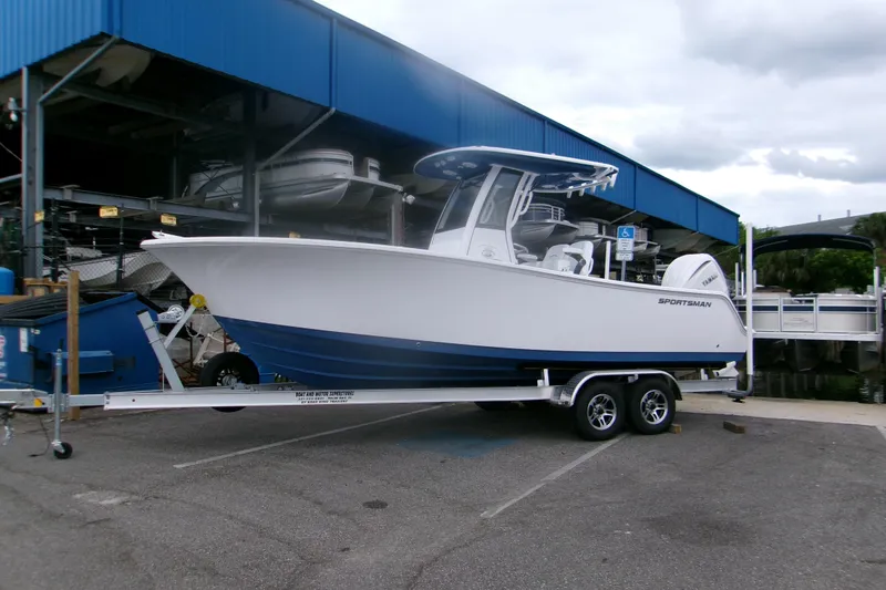 The Image of 2026 Sportsman Open 232 Center Console boat on trailer at marina. - 0