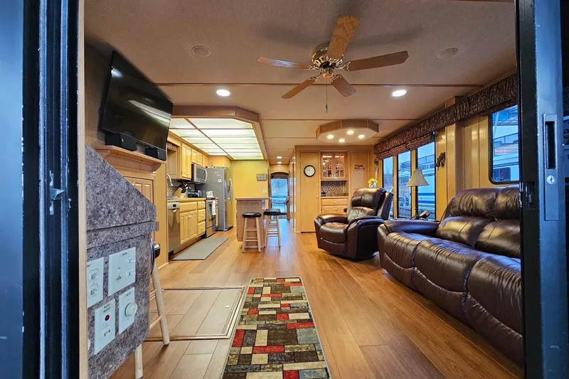 Slide: The Image of Luxurious 2002 Lakeview 16x60 houseboat interior with modern kitchen, leather seating, and wood flooring. - 16