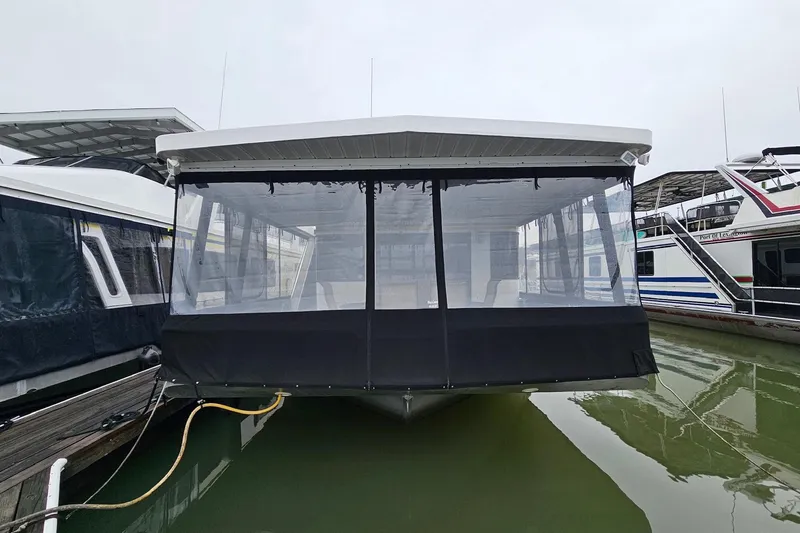 Slide: The Image of 2002 Lakeview 16x60 houseboat docked in a marina, featuring a covered deck. - 2