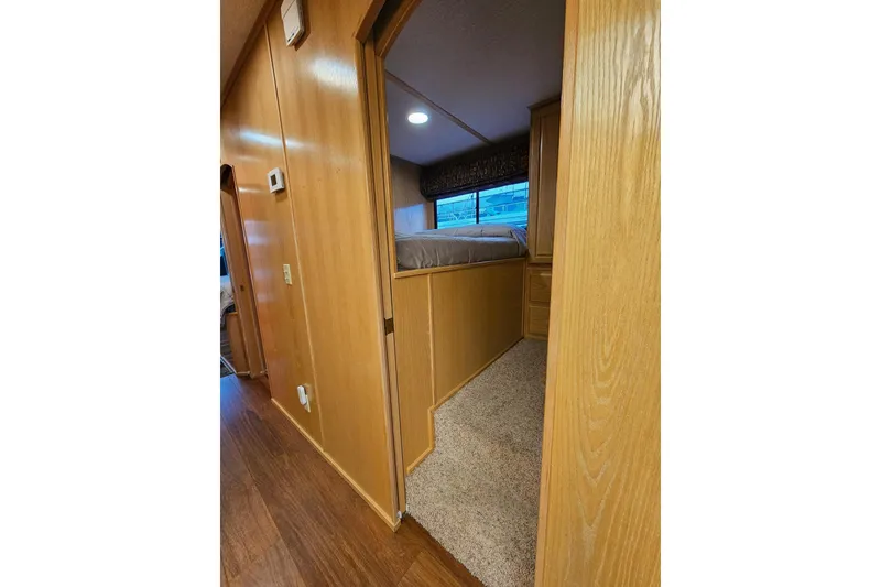 Slide: The Image of Interior view of 2002 Lakeview 16x60 houseboat bedroom with wood paneling and carpeted floor. - 24