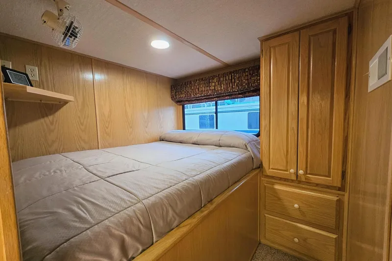 Slide: The Image of Cozy bedroom in 2002 Lakeview 16x60 houseboat with wood paneling and storage cabinets. - 25