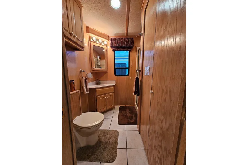 Slide: The Image of Bathroom interior of 2002 Lakeview 16x60 houseboat with wood cabinetry and tiled floor. - 26