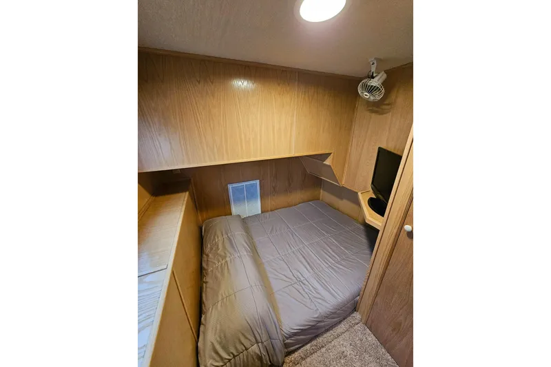 Slide: The Image of Cozy bedroom in 2002 Lakeview 16x60 houseboat with wood paneling and compact design. - 30