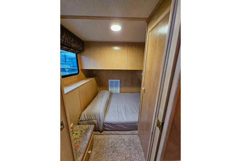 Slide: The Image of Cozy bedroom in 2002 Lakeview 16x60 houseboat with wood paneling and window view. - 32