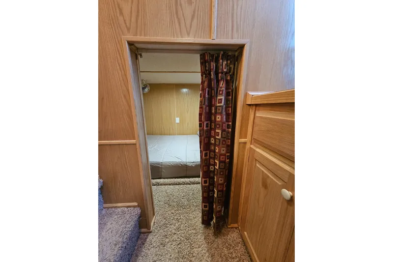 Slide: The Image of Cozy bedroom entrance in 2002 Lakeview 16x60 houseboat with patterned curtain. - 33