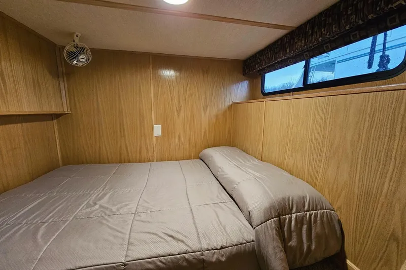 Slide: The Image of Cozy bedroom in 2002 Lakeview 16x60 houseboat with wood paneling and window. - 34