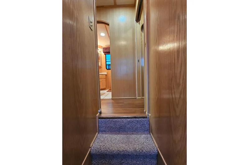 Slide: The Image of Interior hallway of 2002 Lakeview 16x60 houseboat with wooden walls and carpeted steps. - 37