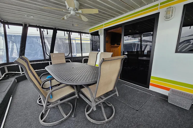 Slide: The Image of Outdoor seating area on a 2002 Lakeview 16x60 houseboat with table and chairs. - 4