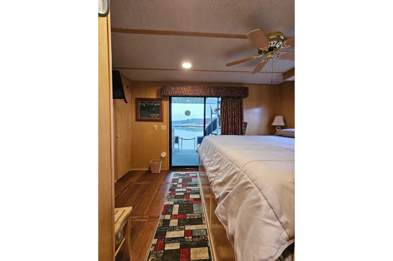 Slide: The Image of Cozy bedroom in 2002 Lakeview 16x60 houseboat with lake view and ceiling fan. - 41