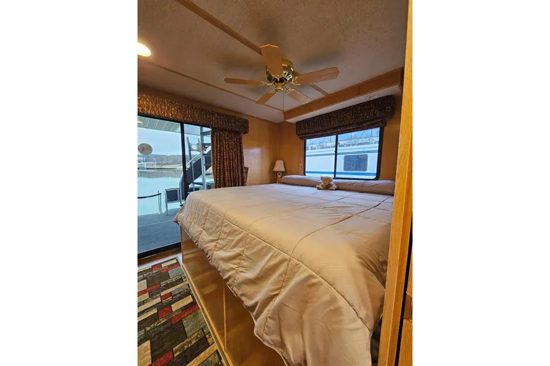 Slide: The Image of Cozy bedroom in 2002 Lakeview 16x60 houseboat with large windows and ceiling fan. - 42