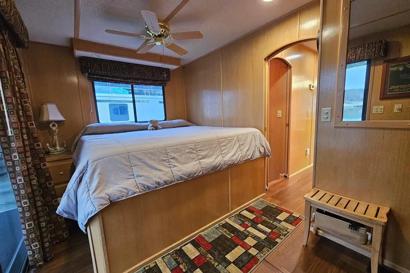 Slide: The Image of Cozy bedroom in 2002 Lakeview 16x60 houseboat with wood paneling and ceiling fan. - 44