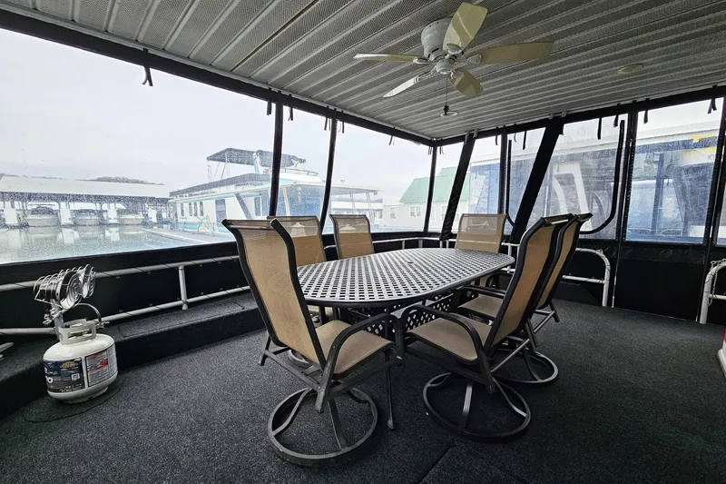 Slide: The Image of Spacious 2002 Lakeview 16x60 houseboat deck with dining set and ceiling fan. - 5