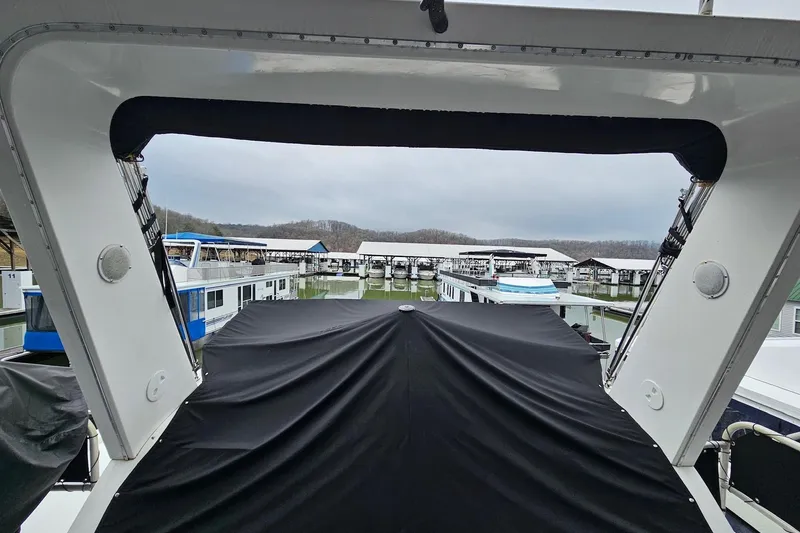 Slide: The Image of 2002 Lakeview 16x60 houseboat docked at a marina, covered deck, overcast sky. - 54