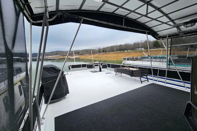 Slide: The Image of Upper deck of a 2002 Lakeview 16x60 houseboat with seating and scenic lake view. - 55