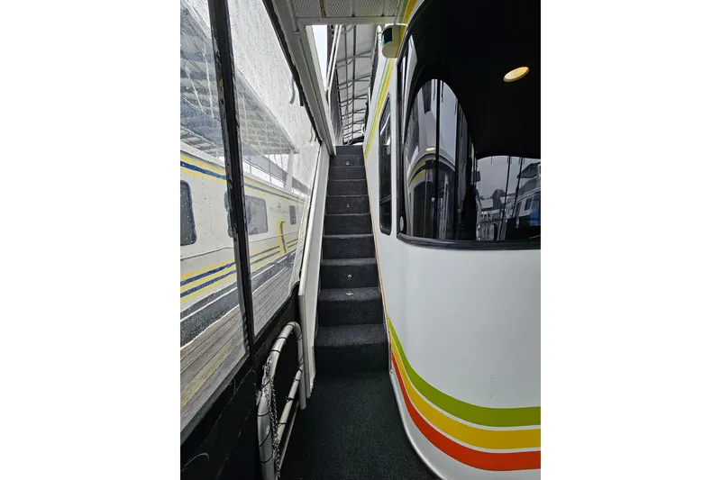 Slide: The Image of Staircase inside 2002 Lakeview 16x60 houseboat with colorful exterior stripes. - 8