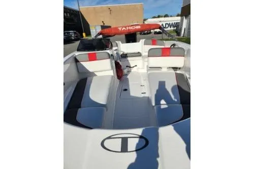 Slide: The Image of 2021 Tahoe T16 boat interior with red and black seating, docked outdoors. - 4