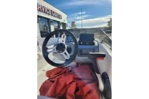 Slide: The Image of 2021 Tahoe T16 boat dashboard with steering wheel and controls, near service center. - 6