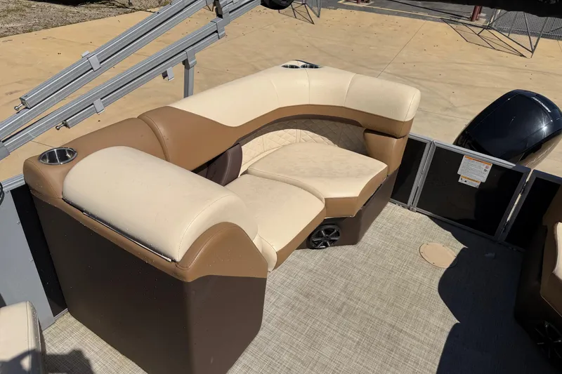 Slide: The Image of 2024 Lowe SS 230 boat interior with beige and brown seating, cup holders, and speaker. - 5
