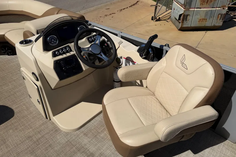 Slide: The Image of 2024 Lowe SS 230 boat helm with beige captain's chair and modern dashboard controls. - 8