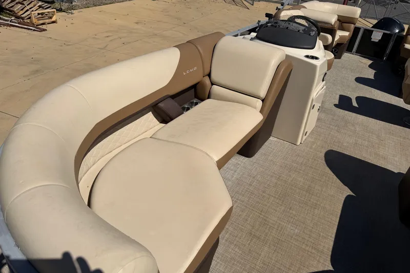 Slide: The Image of 2024 Lowe SS 230 boat interior with beige and brown seating, steering console visible. - 9