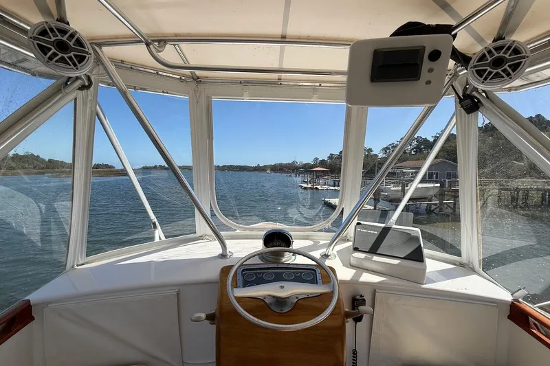 Slide: The Image of Interior view of a 1963 Rybovich 45 Convertible boat cockpit with scenic waterway. - 10