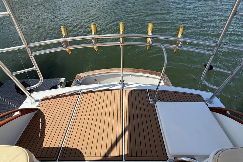 Slide: The Image of 1963 Rybovich 45 Convertible yacht deck with rod holders, overlooking water. - 18