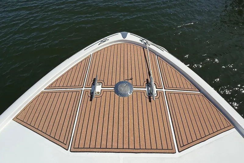 Slide: The Image of 1963 Rybovich 45 Convertible boat deck with teak flooring on calm water. - 21