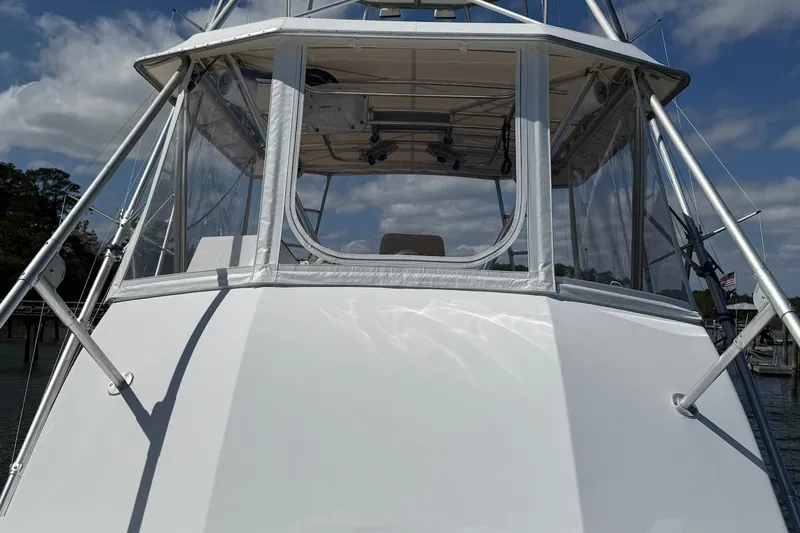 Slide: The Image of 1963 Rybovich 45 Convertible boat with enclosed flybridge, docked under a partly cloudy sky. - 22