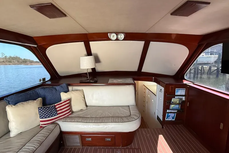 Slide: The Image of 1963 Rybovich 45 Convertible yacht interior with American flag pillow and elegant wood finish. - 33