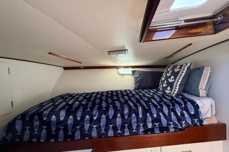 Slide: The Image of Cozy cabin interior of 1963 Rybovich 45 Convertible with nautical-themed bedding. - 45