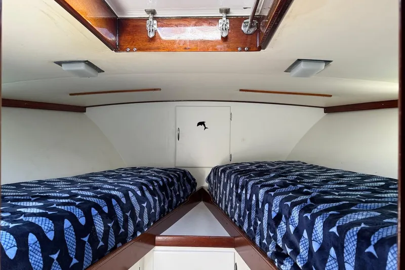 Slide: The Image of Interior cabin of a 1963 Rybovich 45 Convertible boat with twin beds and nautical decor. - 52