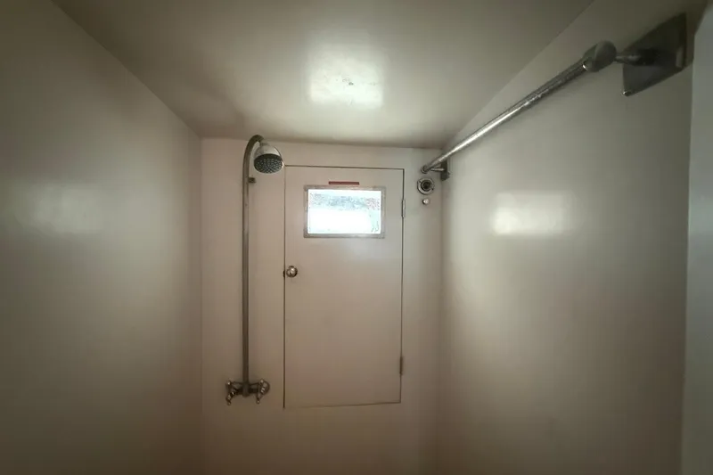 Slide: The Image of Shower area inside a 1963 Rybovich 45 Convertible boat, featuring a simple design. - 53