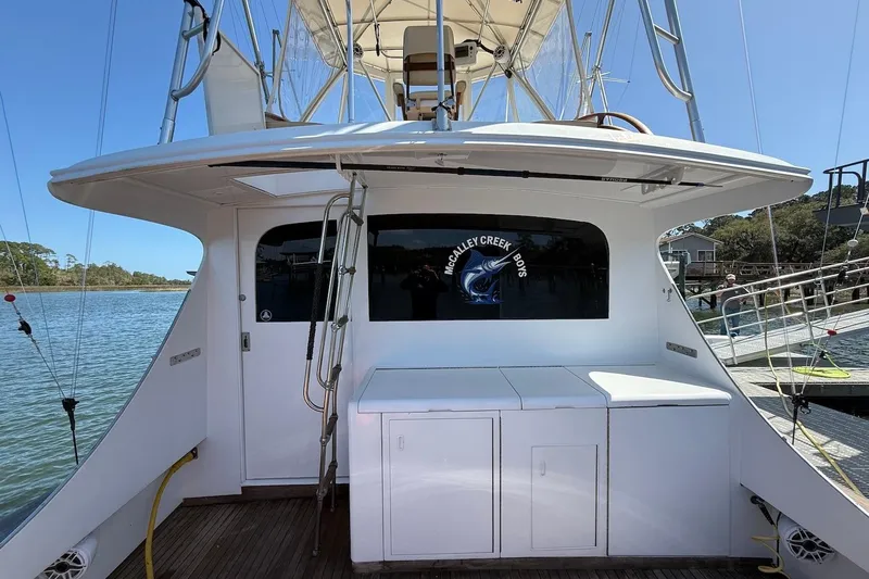 Slide: The Image of 1963 Rybovich 45 Convertible yacht docked, featuring a spacious deck and ladder access. - 7