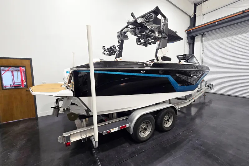 Slide: The Image of 2026 Nautique Super Air Nautique S21 boat on trailer in indoor storage. - 3