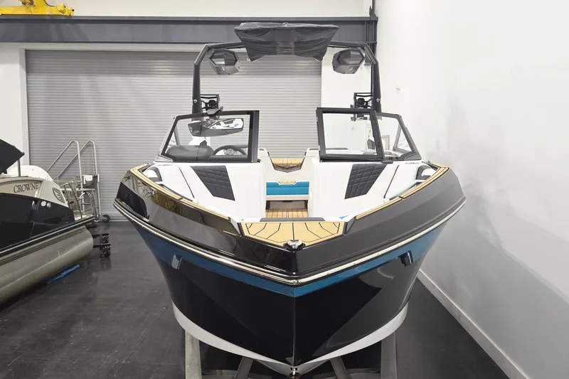 Slide: The Image of 2026 Nautique Super Air Nautique S21 boat in showroom, sleek design, black and white exterior. - 4