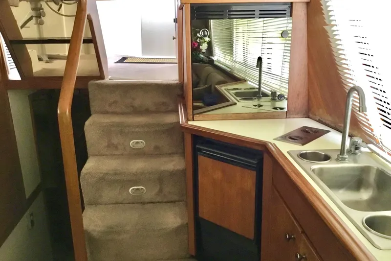 Slide: The Image of Interior of 1994 Bayliner 4788 Pilot House Motoryacht with kitchenette and carpeted stairs. - 10