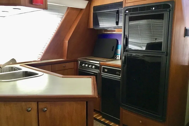 Slide: The Image of Kitchen area of 1994 Bayliner 4788 Pilot House Motoryacht with sink, stove, and refrigerator. - 5
