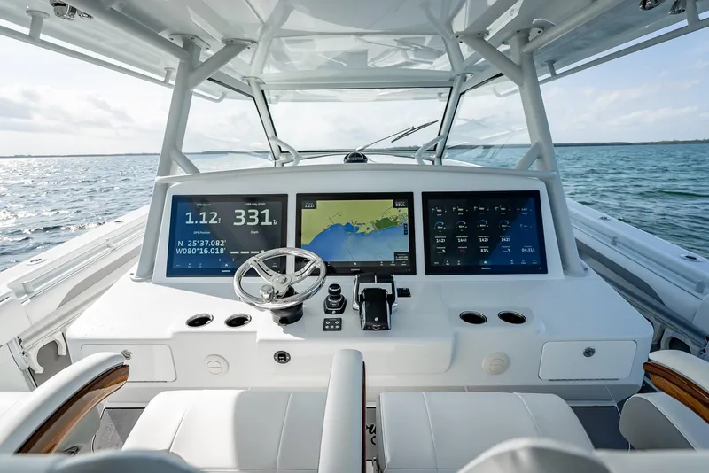 Slide: The Image of 2023 Yellowfin 54 boat dashboard with advanced navigation screens and steering wheel. - 45