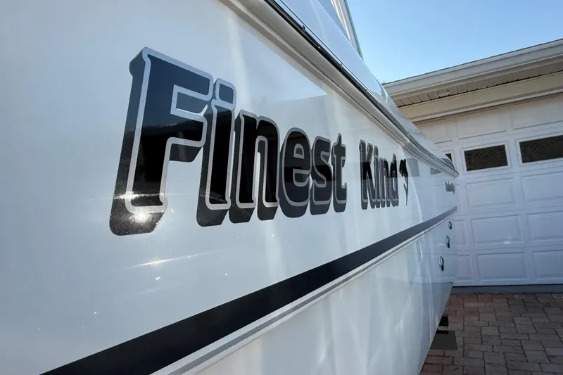 Slide: The Image of Side view of 2014 Carolina Cat 23DC boat with "Finest Kind" lettering. - 16