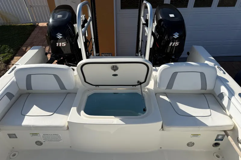 Slide: The Image of 2014 Carolina Cat 23DC boat with dual Suzuki 115 engines and open storage compartment. - 21