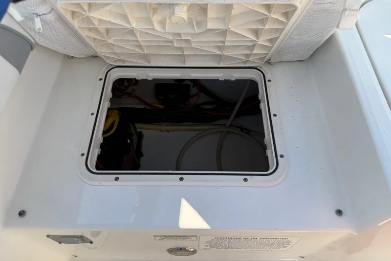 Slide: The Image of Open hatch on a 2014 Carolina Cat 23DC boat, revealing internal wiring and components. - 25