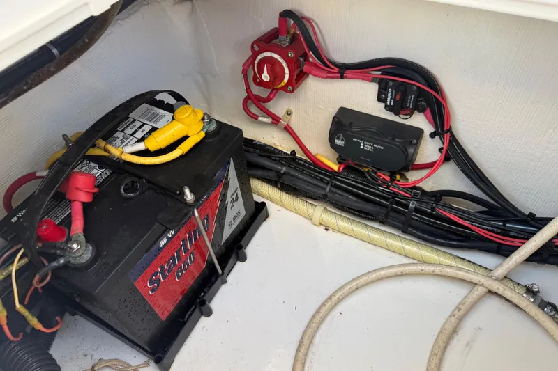 Slide: The Image of 2014 Carolina Cat 23DC boat battery compartment with wiring and connections. - 29