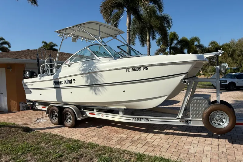 Slide: The Image of 2014 Carolina Cat 23DC boat on trailer, parked in driveway with palm trees. - 3