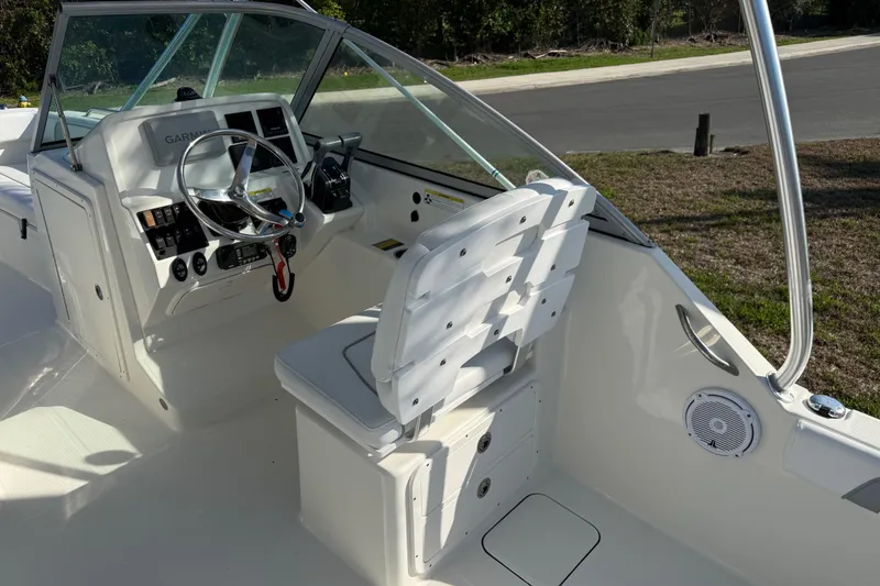 Slide: The Image of 2014 Carolina Cat 23DC boat cockpit with steering wheel and control panel. - 30