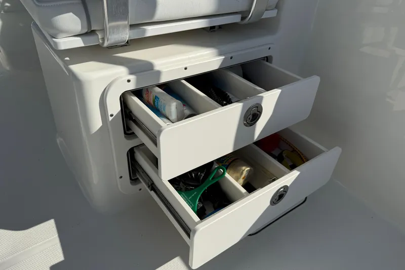 Slide: The Image of Storage drawers on a 2014 Carolina Cat 23DC boat, containing various items. - 31