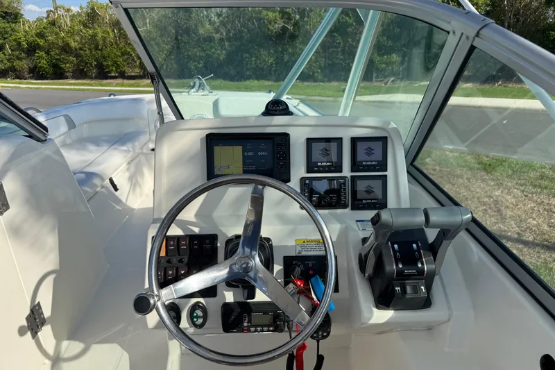 Slide: The Image of 2014 Carolina Cat 23DC boat dashboard with steering wheel and control panels. - 36